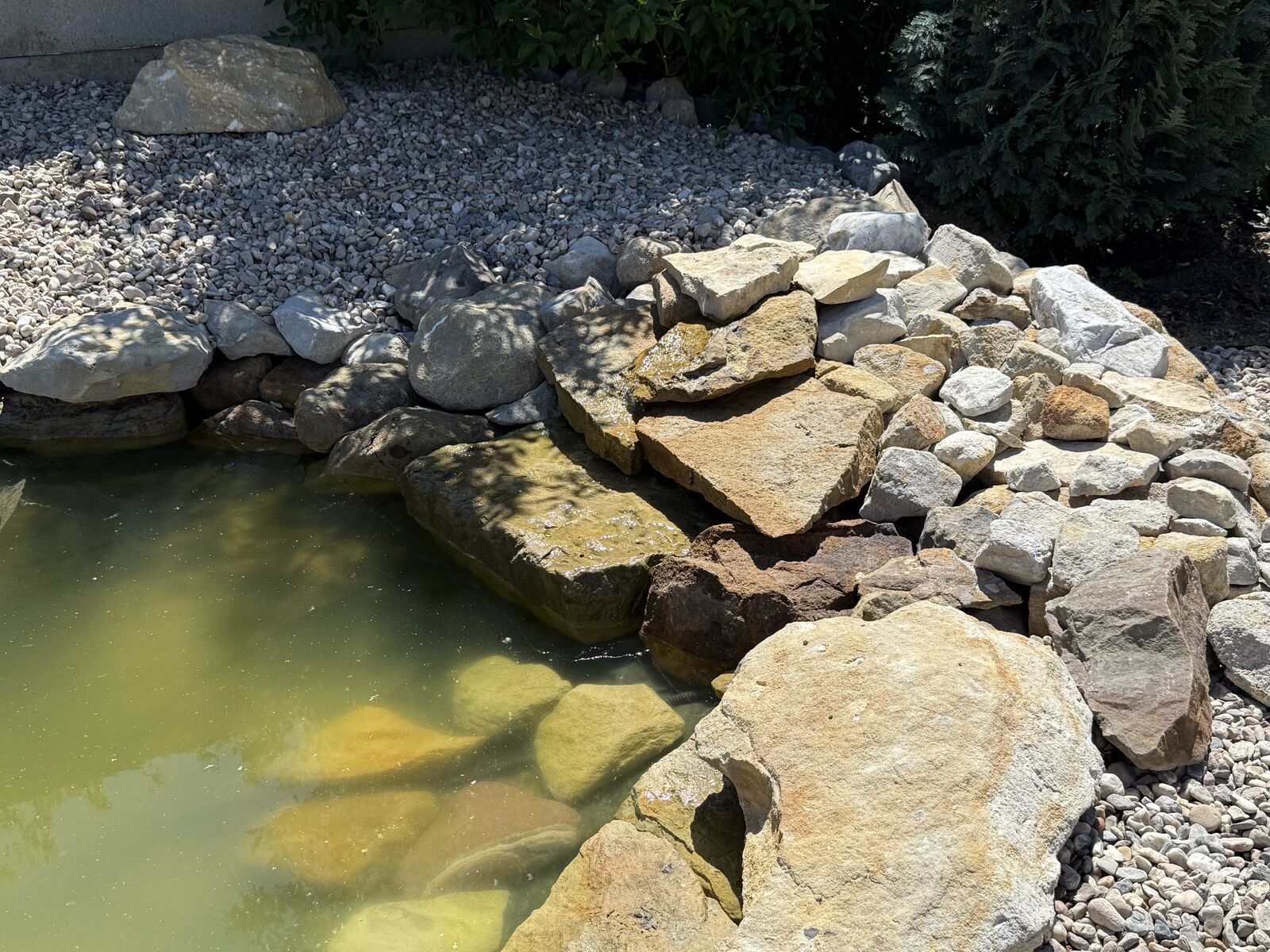 Detail kamenného lemu zahradního jezírka z přírodního pískovce